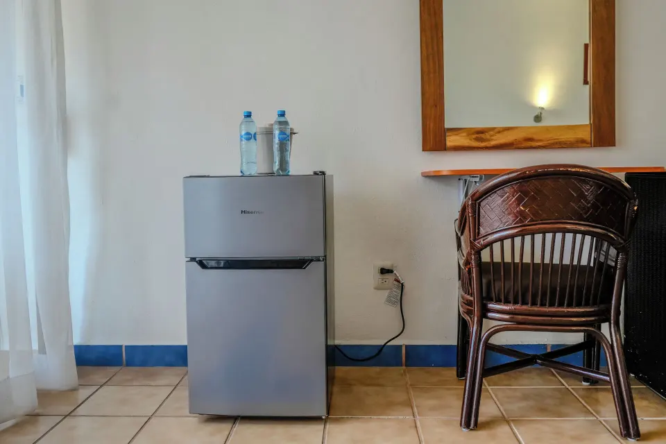 Small refrigerator and desk area in a guest room at Cozumel Hotel & Resort