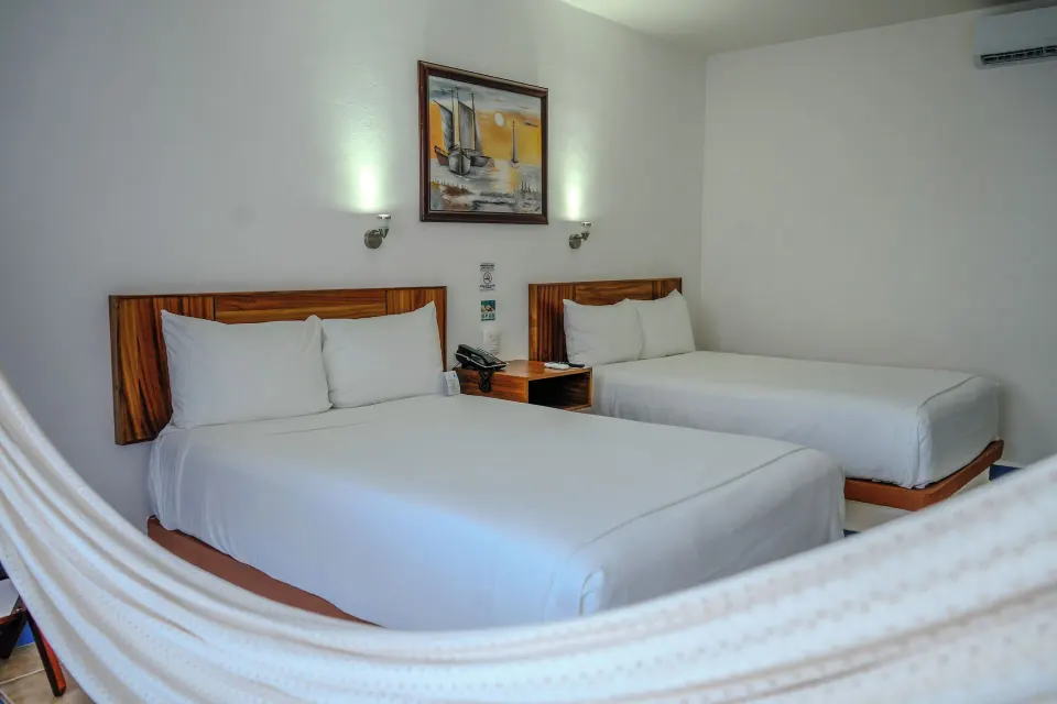 Two double beds with hammock in a guest room at Cozumel Hotel & Resort