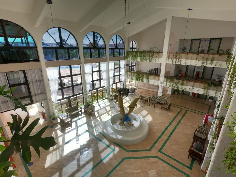 Diagonal view of the lobby atrium with fountain, plants and balcony walkways at Cozumel Hotel & Resort