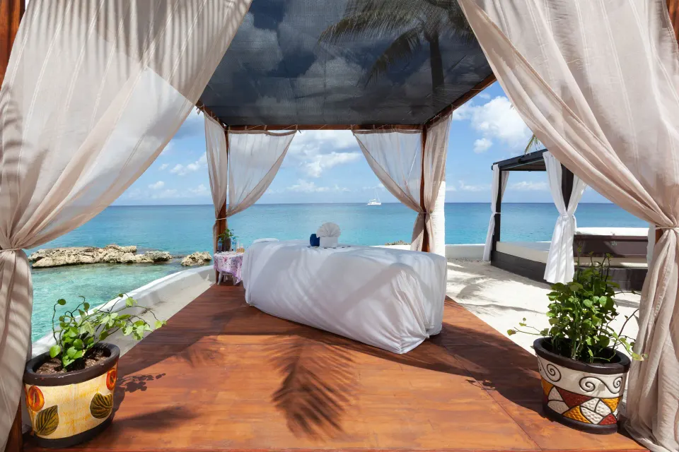 Oceanfront massage cabana with table and curtains at Cozumel Hotel & Resort