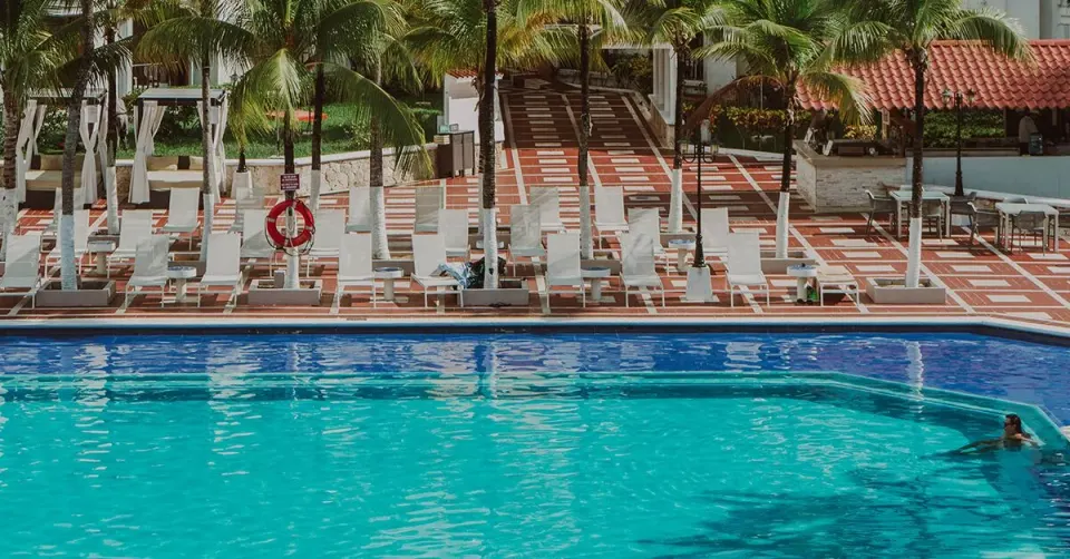 Pool edge with loungers and lifebuoy at Cozumel Hotel & Resort