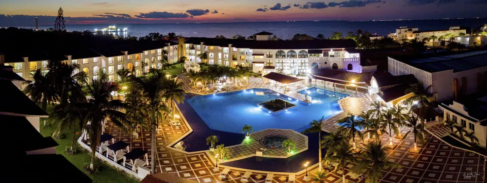 Nighttime view of the resort pool and buildings lit up at Cozumel Hotel & Resort