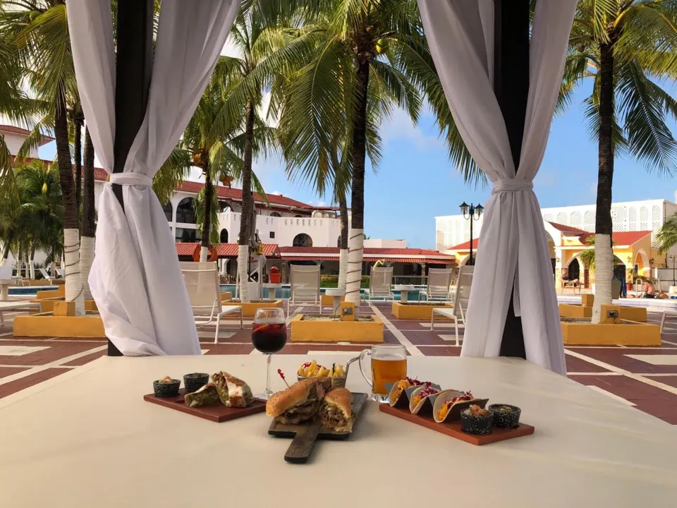 Poolside cabana table with appetizers and drinks at Cozumel Hotel & Resort