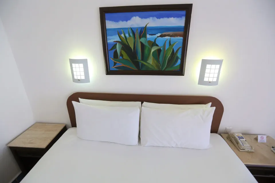 Overhead view of king bed, bedside lamps and artwork at Cozumel Hotel & Resort