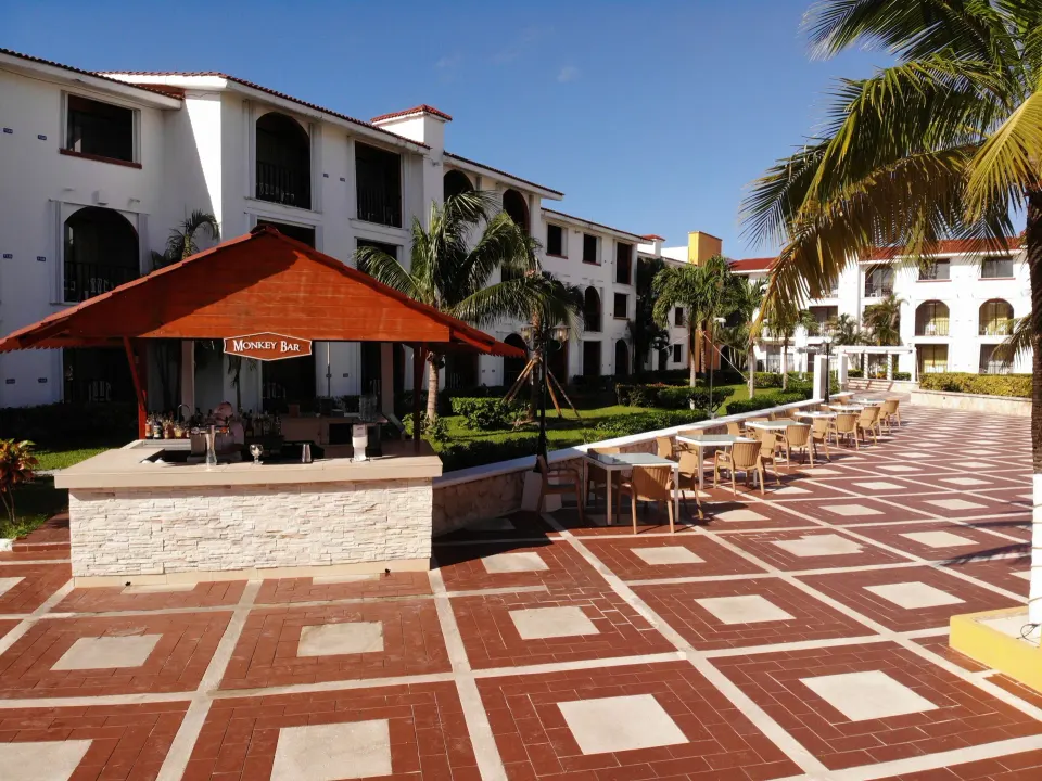 Open courtyard terrace with bar hut and rows of outdoor seating at Cozumel Hotel & Resort