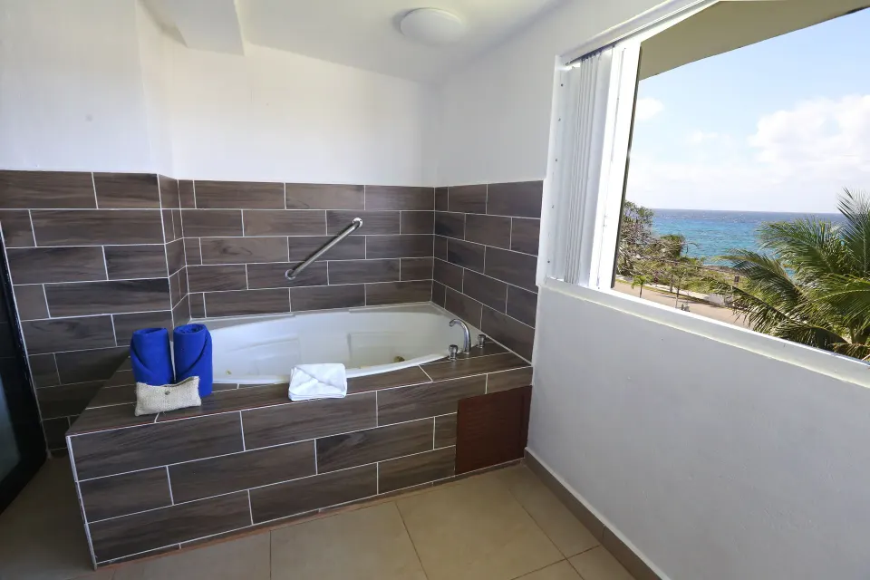 Close view of the tiled whirlpool tub and ocean window at Cozumel Hotel & Resort.