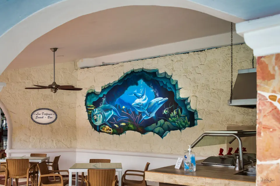 Dining seating area with a colorful mural on the wall at Cozumel Hotel & Resort
