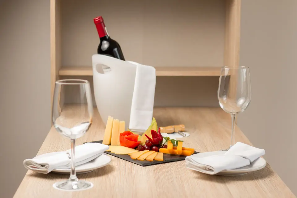 Wine bottle in ice bucket and cheese platter on a table at Cozumel Hotel & Resort