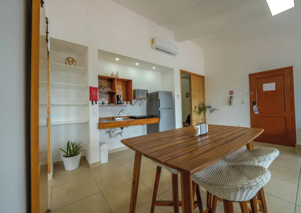 Premier Suite kitchenette and dining area with wooden table at Cozumel Hotel & Resort