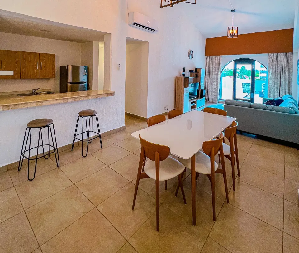 Presidential Suite dining table and living area with arched window at Cozumel Hotel & Resort