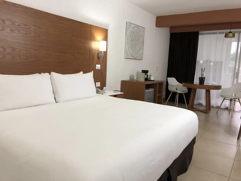 King bed and seating area in a Superior Room with Jacuzzi at Cozumel Hotel & Resort