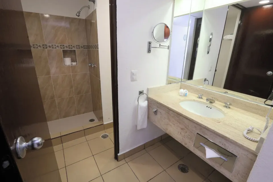Bathroom vanity and walk-in shower in a Superior Room at Cozumel Hotel & Resort