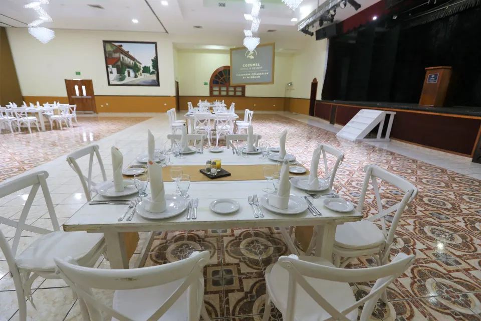 Banquet tables and stage in a large event ballroom at Cozumel Hotel & Resort