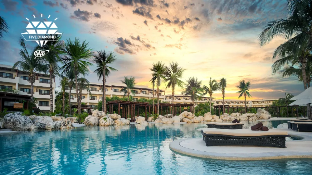 Secrets Maroma Beach Riviera Cancun adults-only luxury all-inclusive beach resort with palm-lined pool and white-sand beachfront in Riviera Cancun, Mexico.