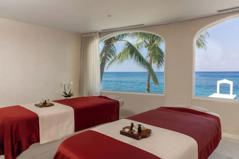 Spa treatment room with two massage tables and ocean view at Cozumel Palace