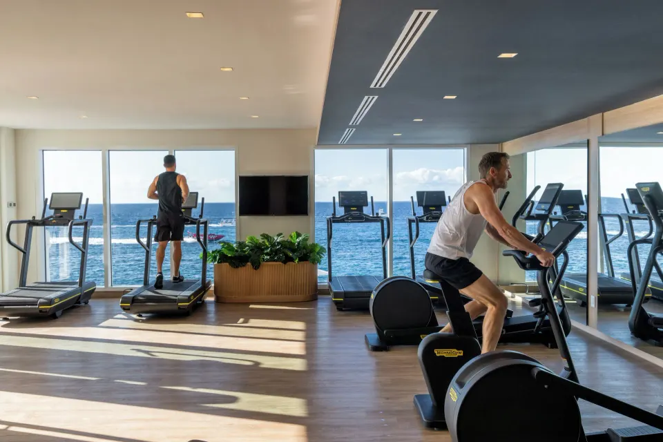 Ocean-view fitness center with cardio machines at Cozumel Palace