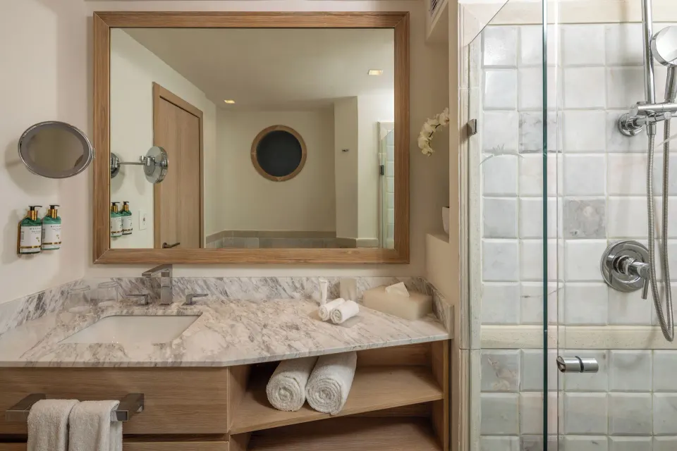 Marble vanity and glass shower in a guest bathroom at Cozumel Palace.