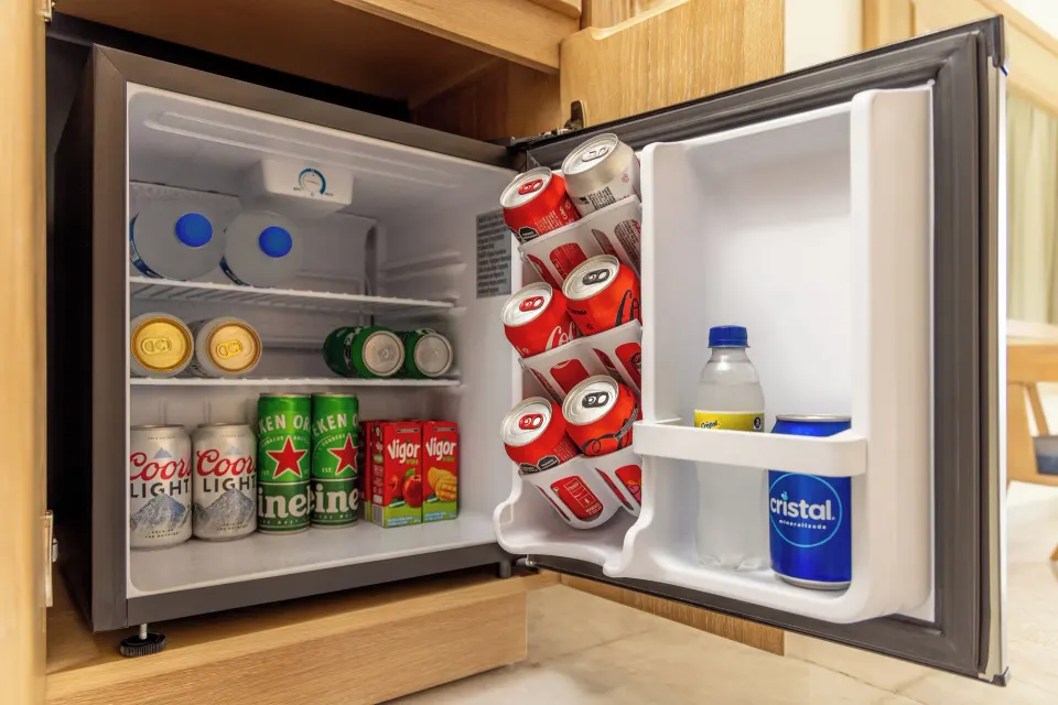 Mini fridge stocked with beverages inside a guest room at Cozumel Palace.