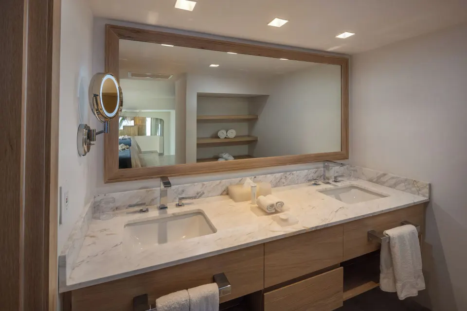 Double-sink marble vanity and large mirror in a bathroom at Cozumel Palace.