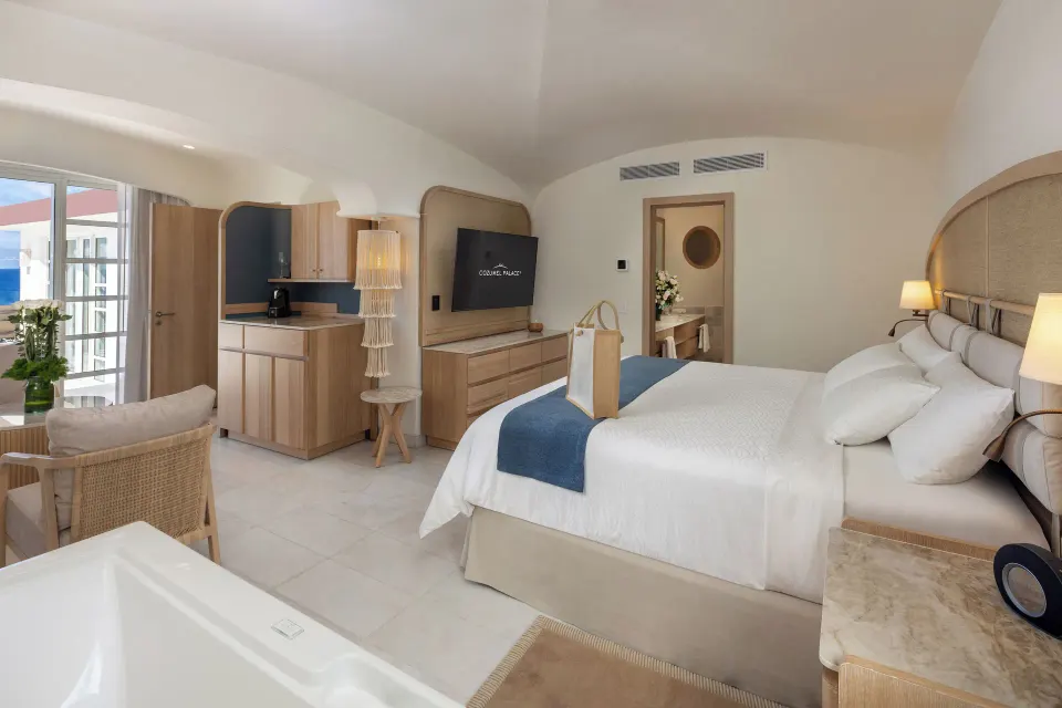 Bright guest room with king bed, balcony and marble floors at Cozumel Palace.