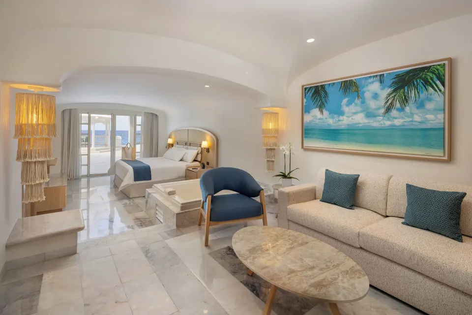 Suite seating area with sofa, armchair and tropical artwork at Cozumel Palace.