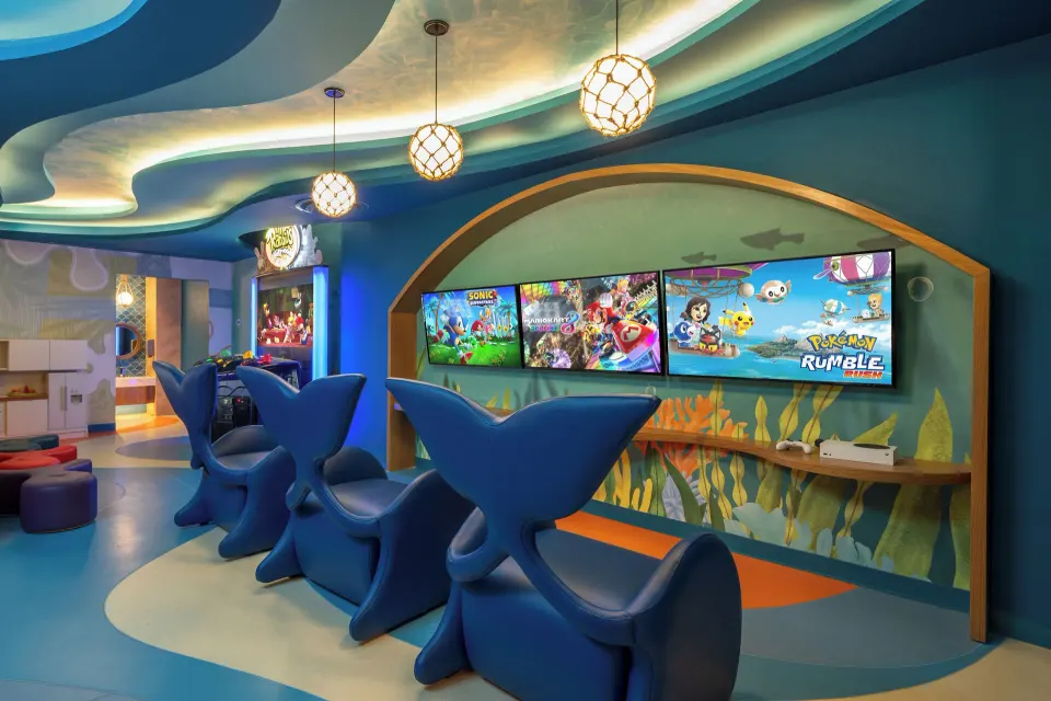 Colorful children's gaming stations with screens and blue seating at Cozumel Palace