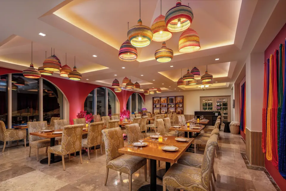 Colorful indoor restaurant dining room with hanging basket lights at Cozumel Palace