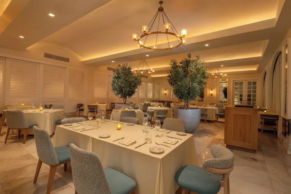 Elegant dining room with chandeliers and potted trees at Cozumel Palace