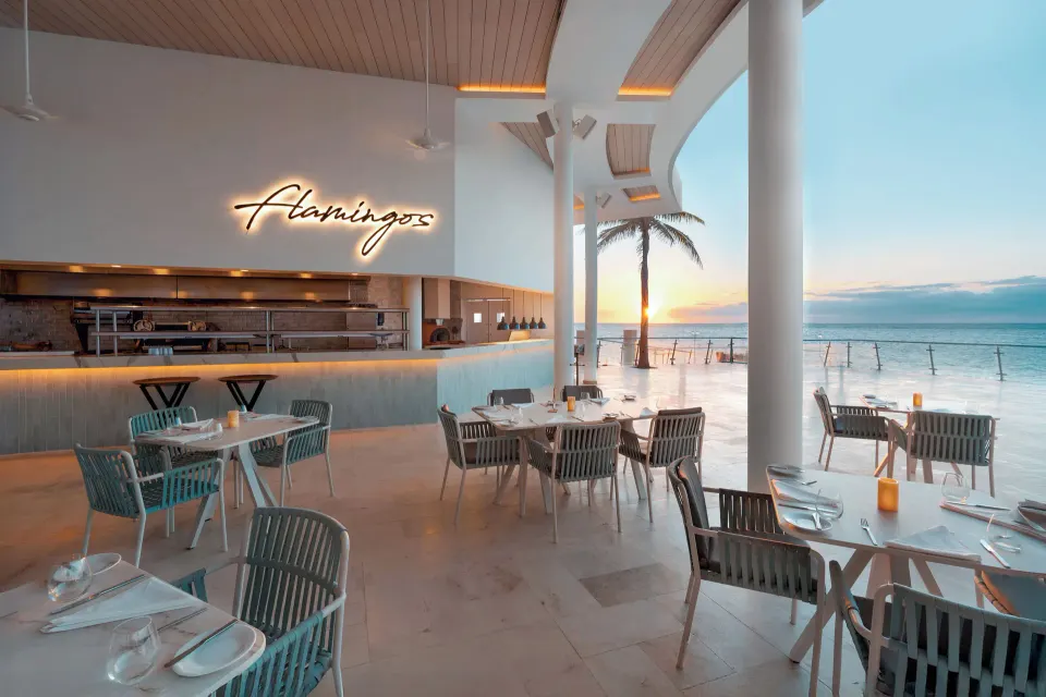 Open-air Flamingos restaurant dining area with ocean view at Cozumel Palace