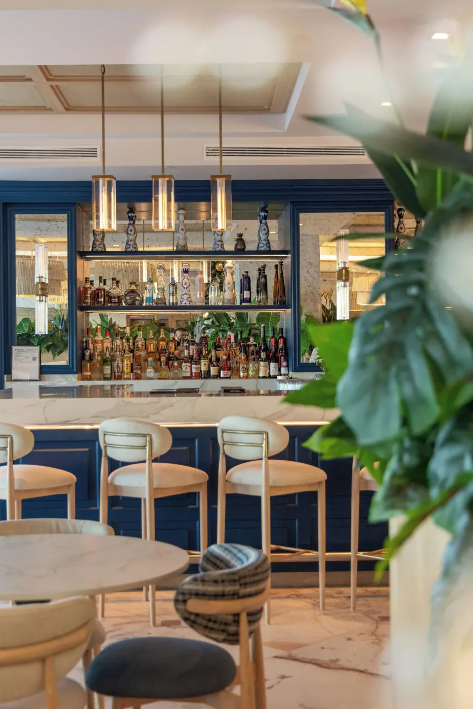 Interior bar with stocked back shelves and barstools at Cozumel Palace.