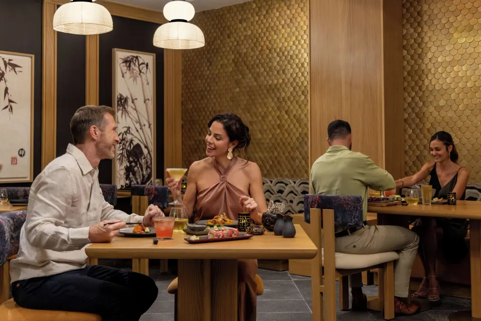 Couples dining in a gold-accented Asian-style restaurant at Cozumel Palace
