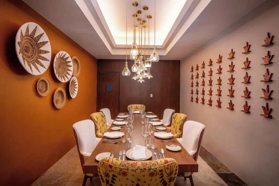 Private dining room with long table and decorative wall pieces at Cozumel Palace
