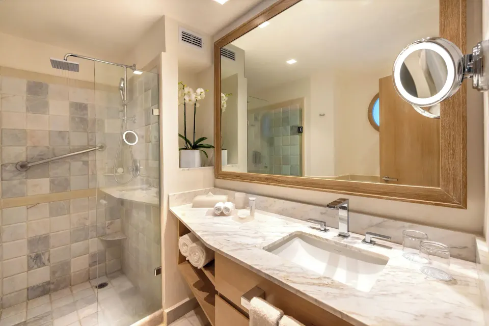 Suite bathroom with marble counter and glass shower at Cozumel Palace