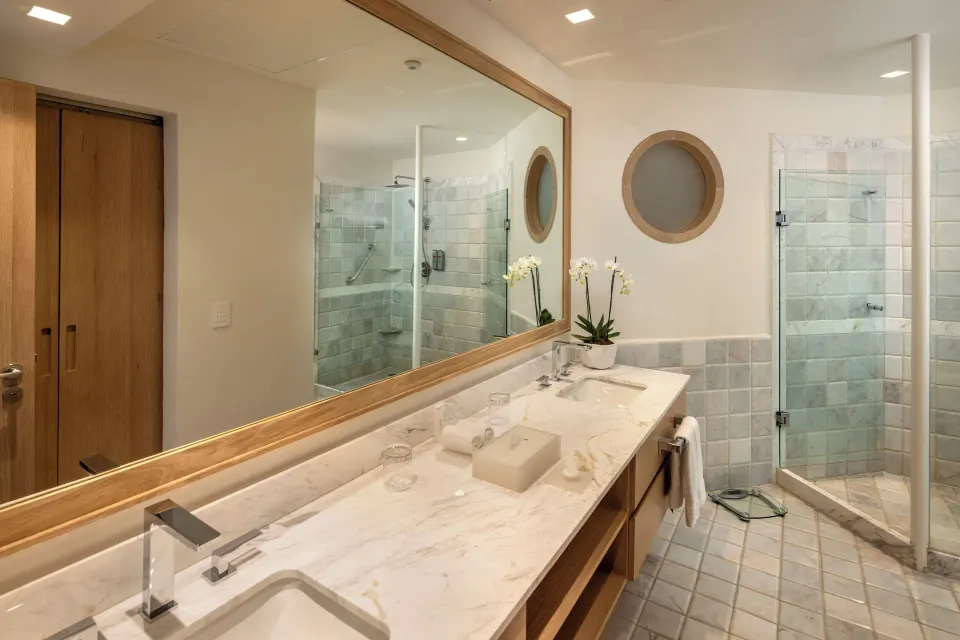 Double-sink marble vanity and walk-in shower in the Superior Two Bedroom Presidential Suite bathroom at Cozumel Palace