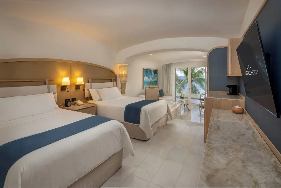Villa three bedroom suite guest room with two double beds at Cozumel Palace.