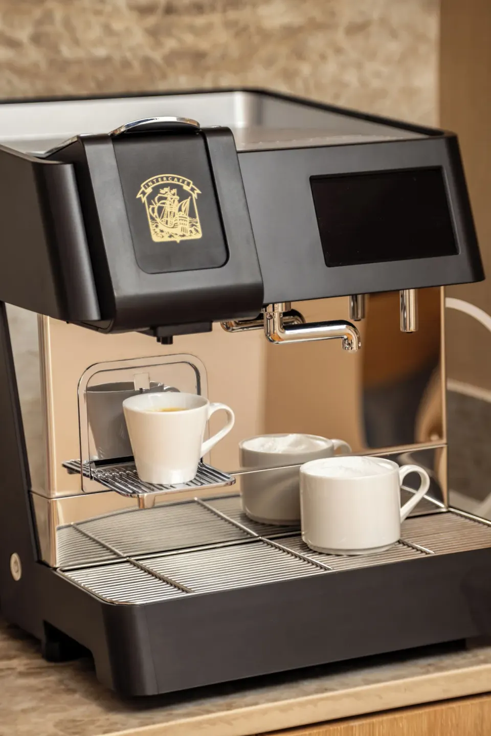 Close-up of an in-suite espresso machine with cups at Cozumel Palace.