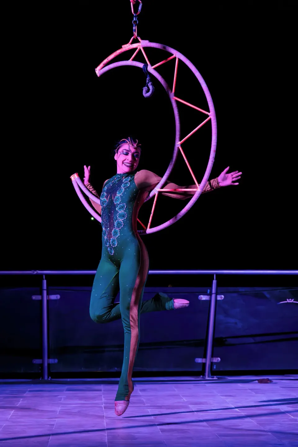 Aerial performer on a crescent hoop during an evening show at Cozumel Palace