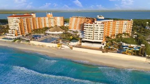 Beachfront aerial view with pools and water slides at Crown Paradise Club Cancun.