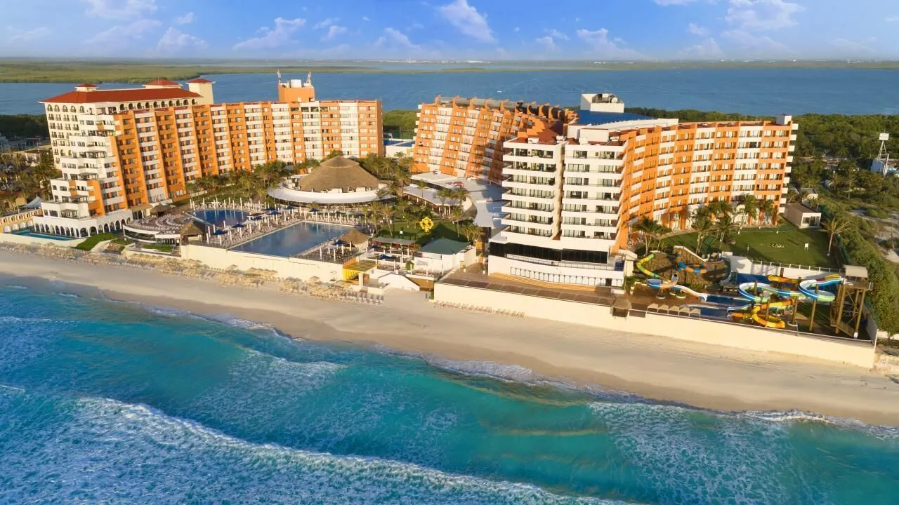 Beachfront aerial view with pools and water slides at Crown Paradise Club Cancun.