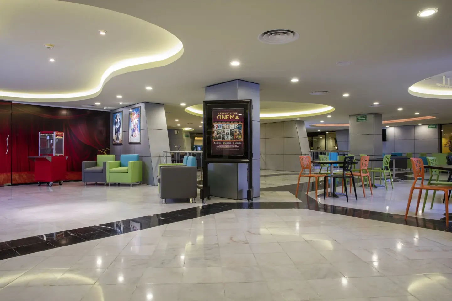 Cinema and seating area with colorful chairs at Crown Paradise Club Cancun.