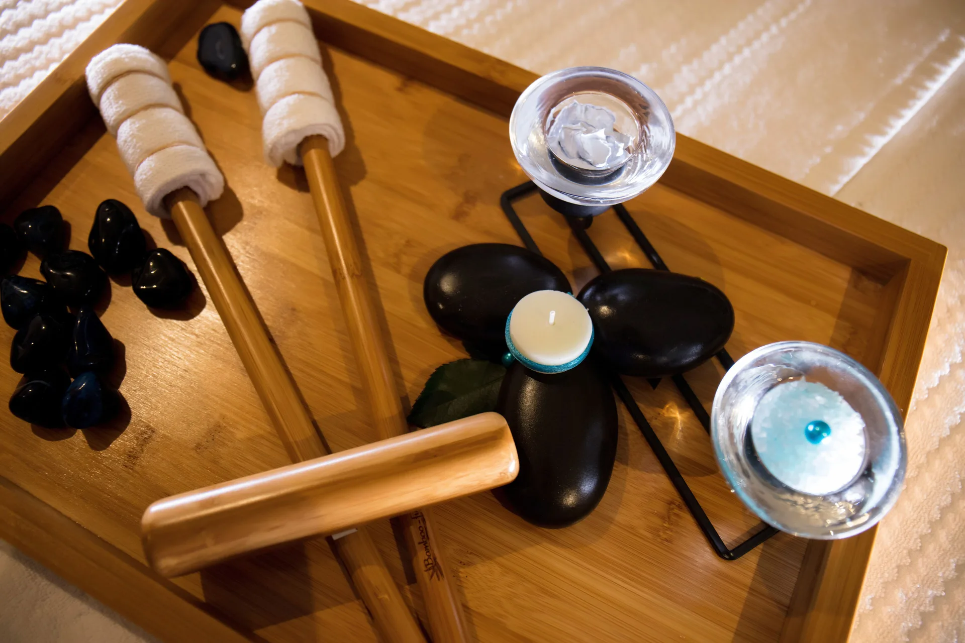 Spa stones, candles, and massage tools on a tray at Crown Paradise Club Cancun.
