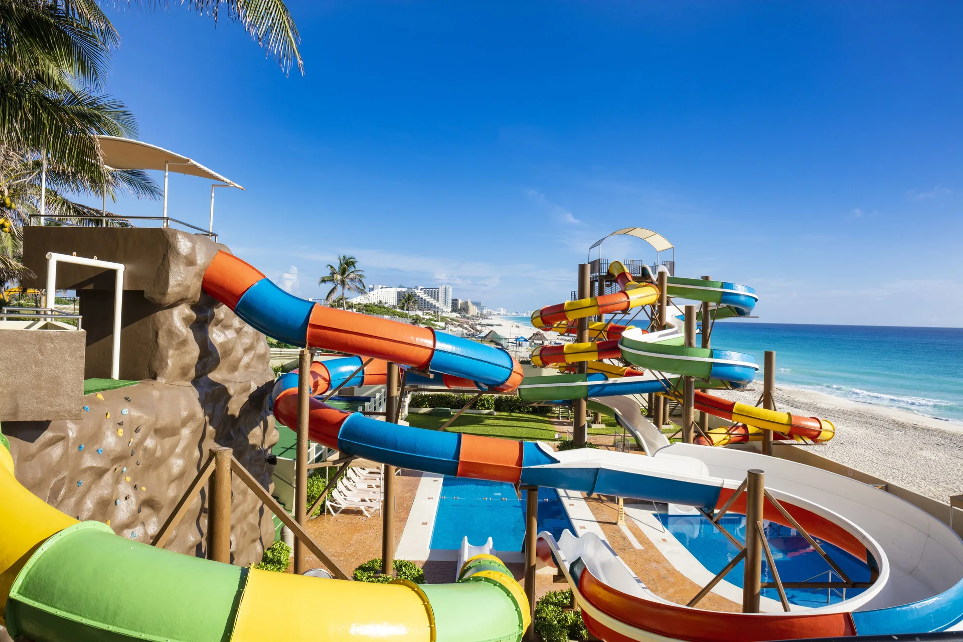 Water slide complex at Crown Paradise Club Cancun with ocean and beach views.