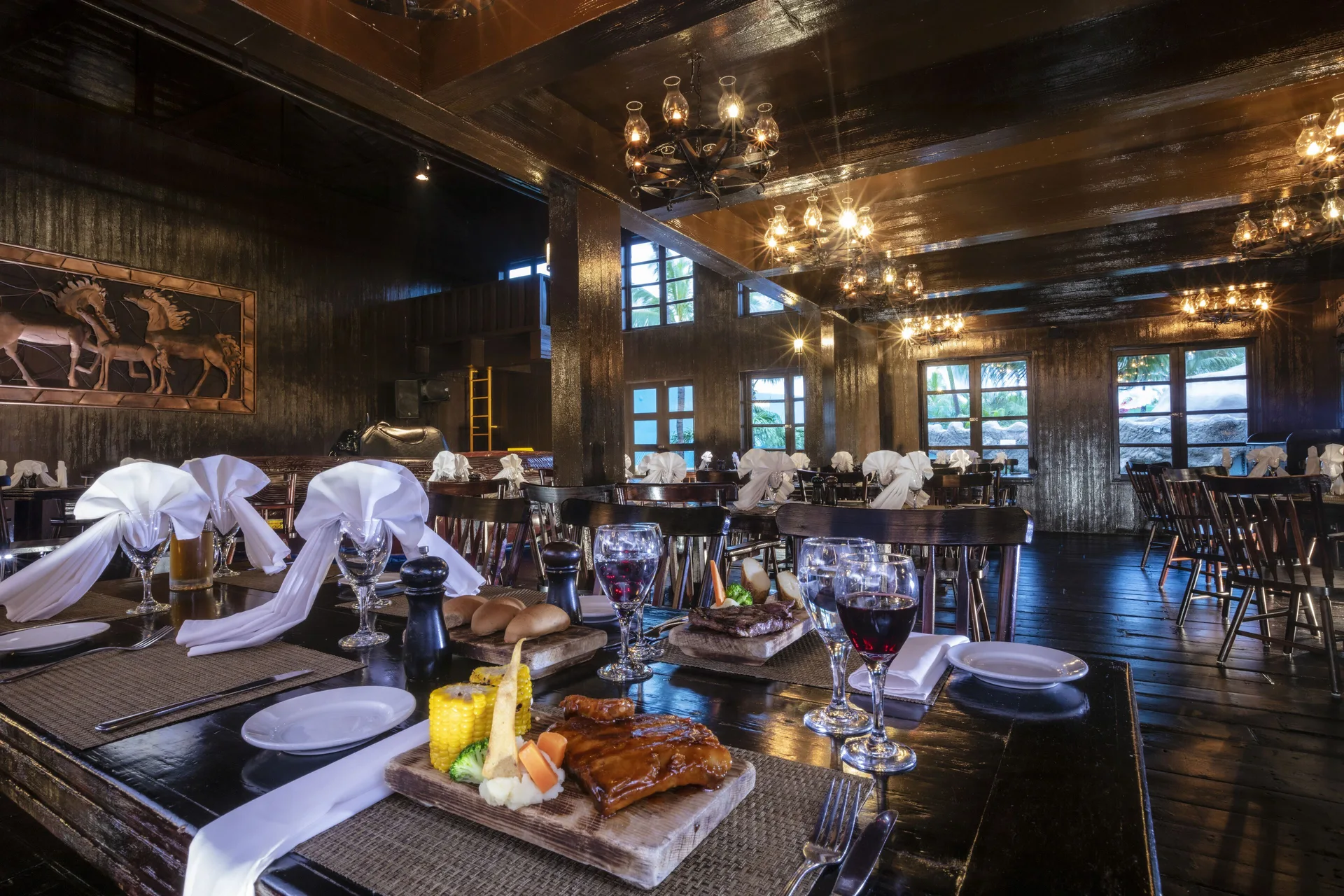 Rustic dining room with set tables and dark wood at Crown Paradise Club Cancun.