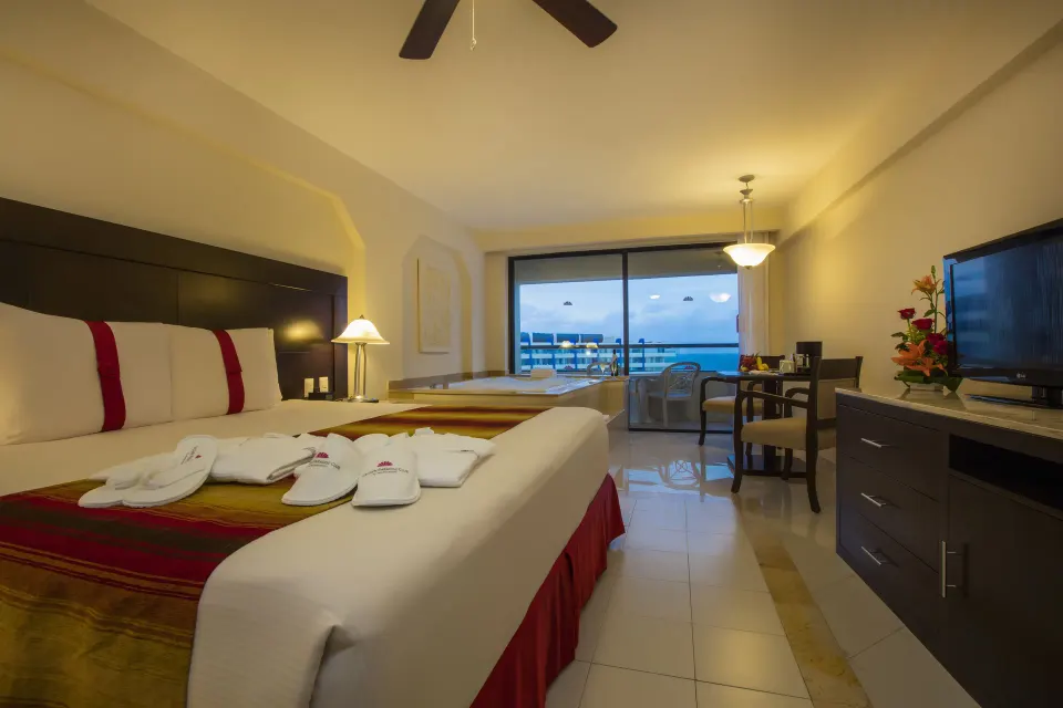 Crown Paradise Club Cancun at Crown Paradise Club Cancun with king bed, TV, dining table and balcony view.