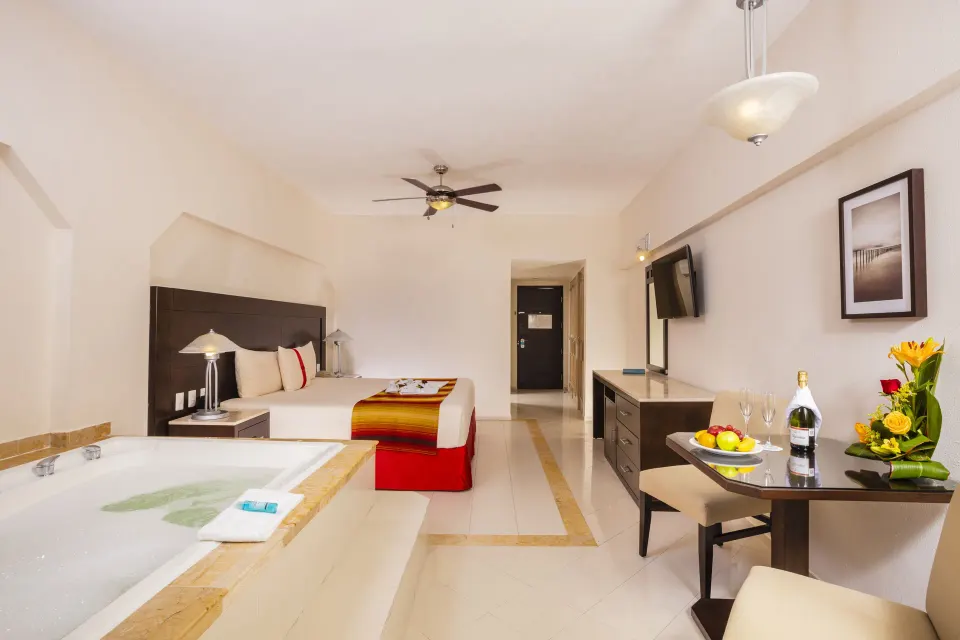 Crown Paradise Club Cancun at Crown Paradise Club Cancun with king bed, in-room tub and small dining table.