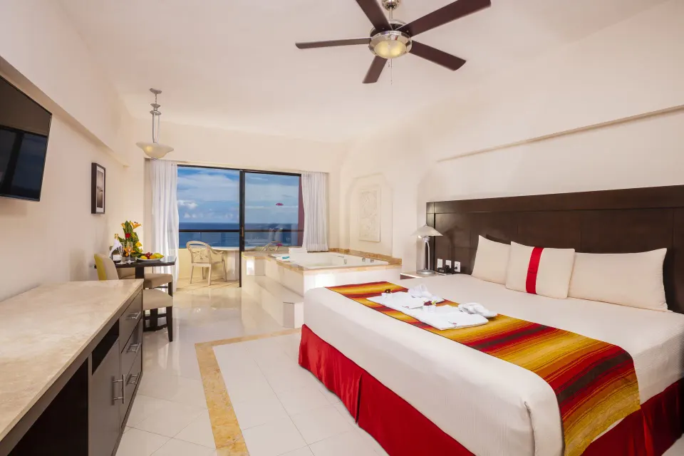 Crown Paradise Club Cancun at Crown Paradise Club Cancun with king bed, in-room tub, balcony and ocean view.