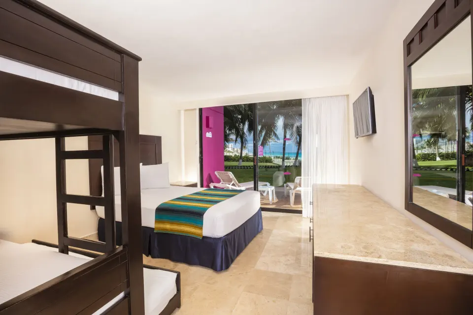 Family Suite Paradise with bunk bed, king bed, and patio view at Crown Paradise Club Cancun.