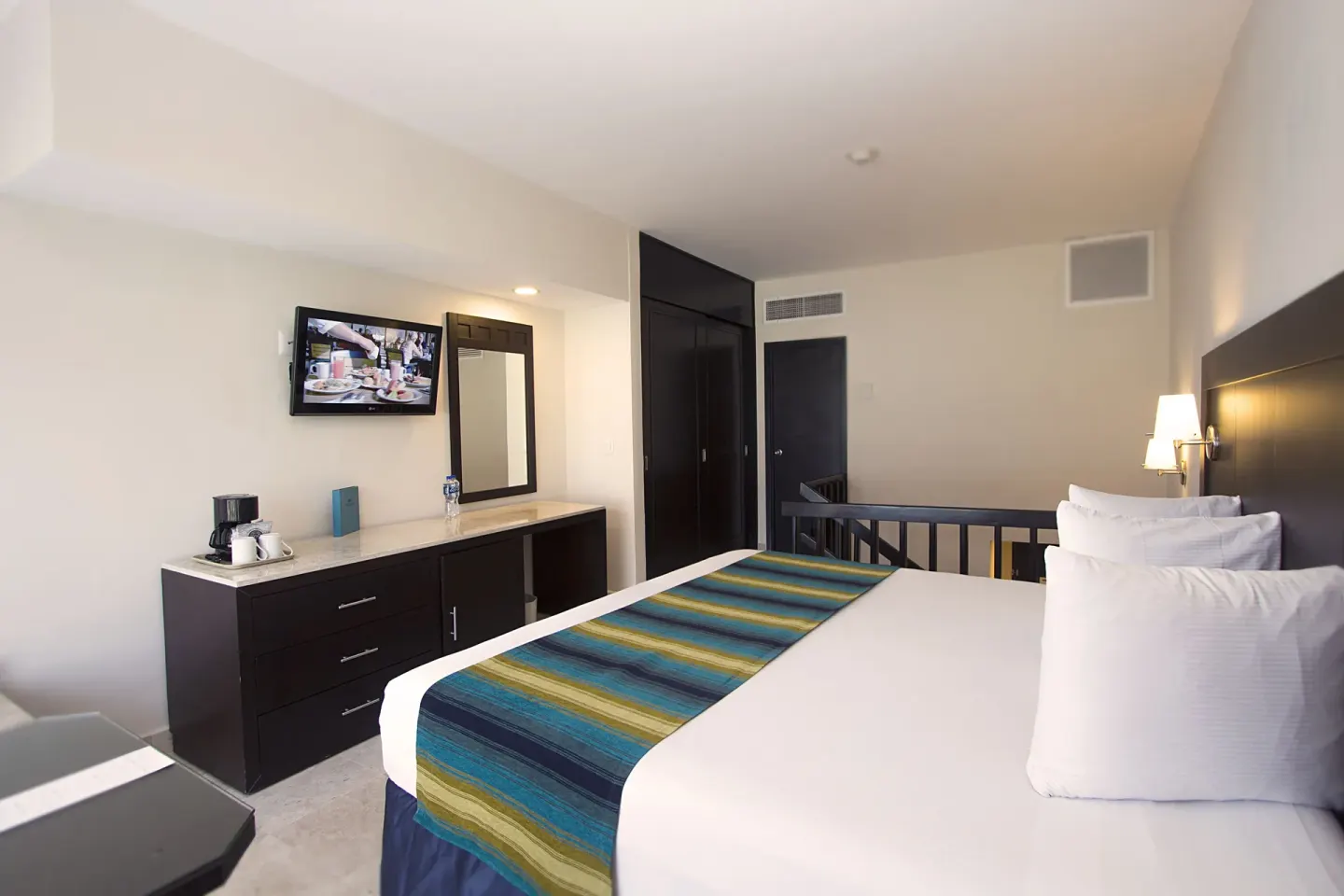Family Suite Paradise bedroom with king bed and TV at Crown Paradise Club Cancun.