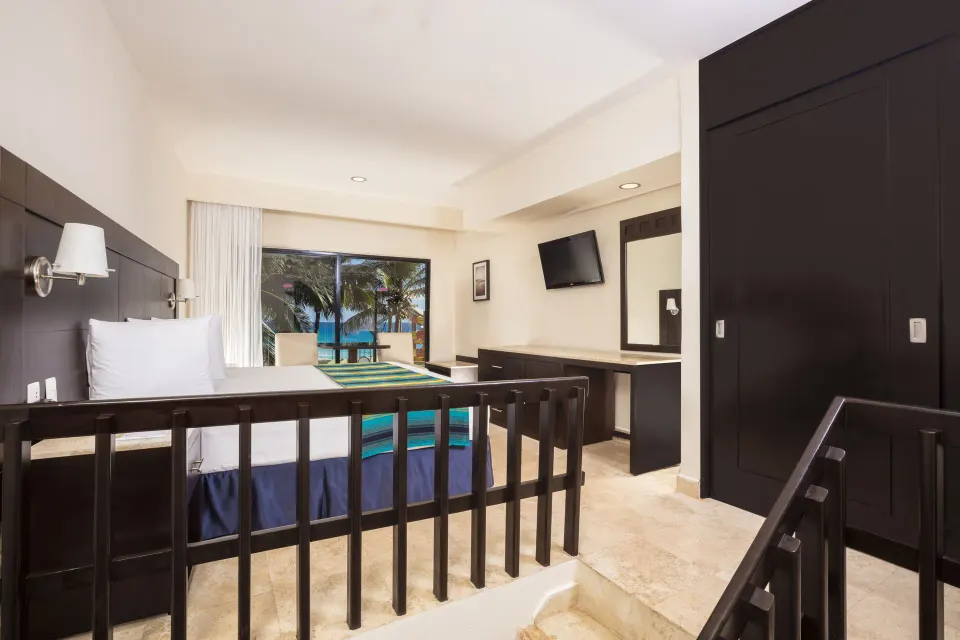 Family Suite Paradise upper bedroom with king bed and wardrobe at Crown Paradise Club Cancun.