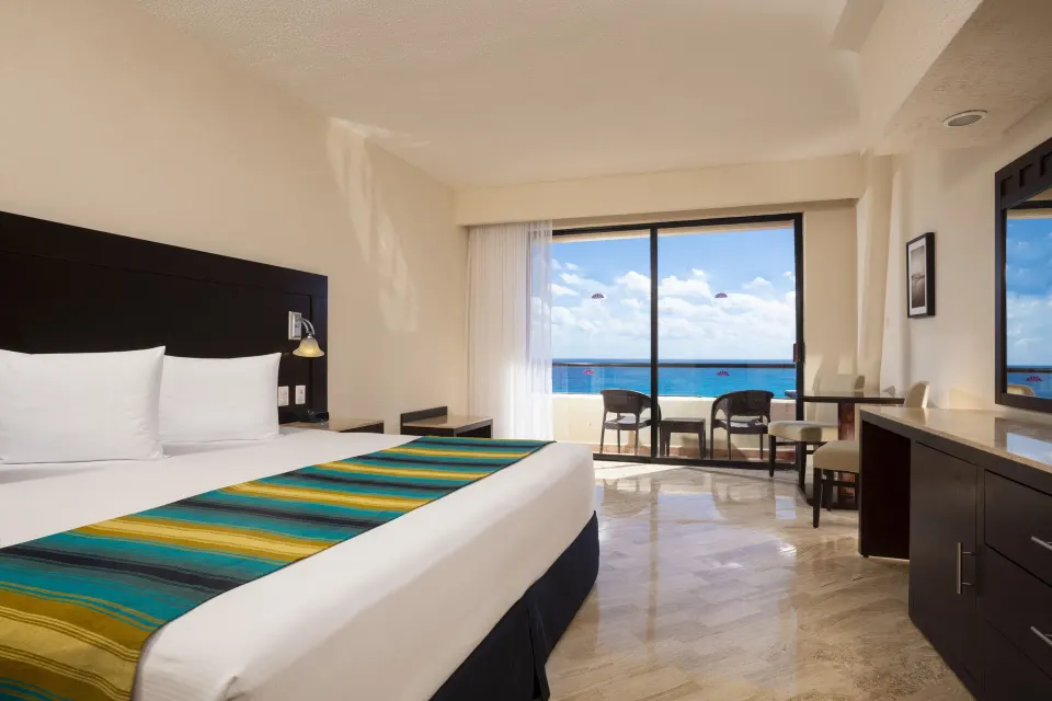 Standard Ocean View king room with balcony seating and sea view at Crown Paradise Club Cancun.